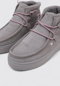 Botas de tobillo de ante gris con cordones rosas, forro de felpa suave, punta redondeada y suela de goma gris gruesa. Diseño minimalista y detalles de costura.