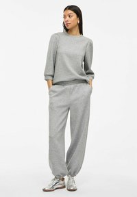 Grauer Sweatshirt und passende Jogginghose aus Baumwollmischgewebe; das Sweatshirt hat einen Rundhalsausschnitt und Dreiviertelärmel; lockere Passform.