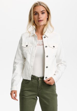 Chaqueta de denim blanca con cierre de botón, dos bolsillos en el pecho y un cuello. Lleva puesta una blusa clara y se combina con pantalones de color verde oliva.