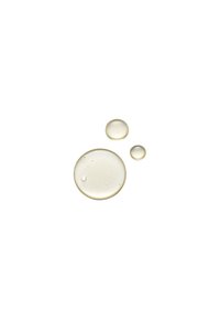 Trois gouttes d'huile ambrée claire, de tailles variées, avec une texture lisse et un éclat subtil, posées sur un fond blanc.