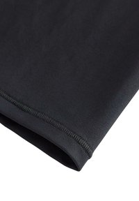 Černý elastický materiál s hladkým povrchem, představující ploché švy podél okrajů pro trvanlivost. Materiál je lehký a flexibilní.