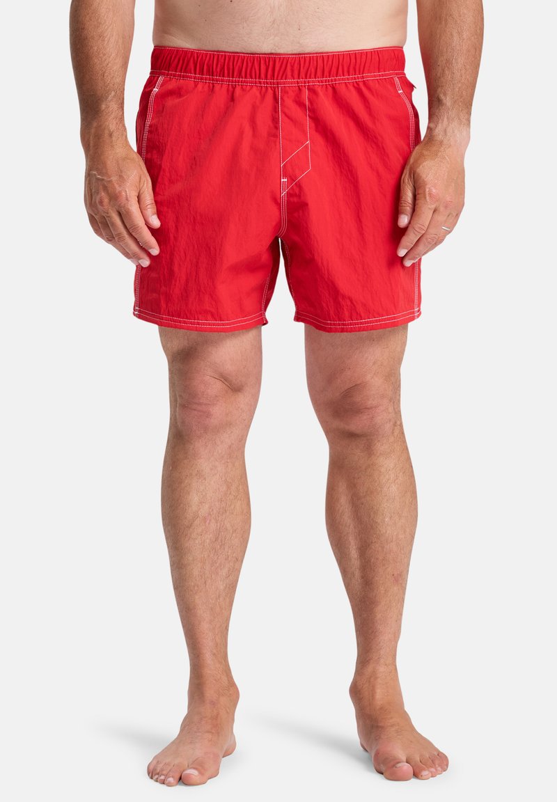 Red swim shorts with elastic waistband, featuring white stitching, a comfortable fit, and a smooth, lightweight fabric.