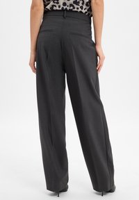 Wijdlopende broeken van donkergrijze stof met een gladde textuur, voorzien van een hoge taille en minimalistische achterzakdetails.