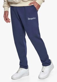 Mørkeblå sweatpants i bomuldsblanding, med teksten "Dropsize" i hvid på venstre lår, med sidelommer og elastiske manchetter.