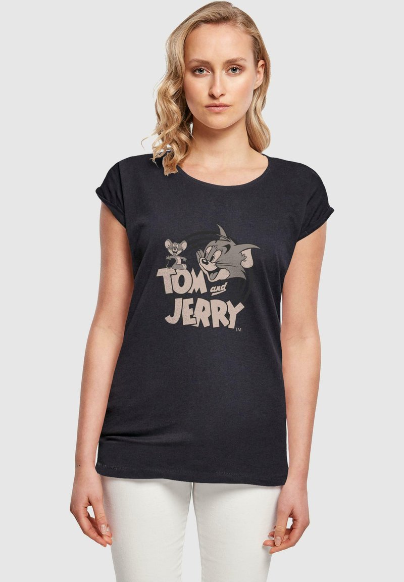 Svart T-skjorte med grafisk trykk av tegneseriefigurene Tom og Jerry. Korte ermer og rund hals, laget av mykt stoff.