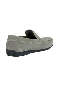 Scarpa slip-on in suede grigio con punta arrotondata, dettagli cuciti e suola in gomma nera. Presenta una tomaia morbida e textured.