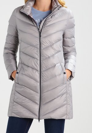 Giacca imbottita grigio chiaro con motivo a zigzag, chiusura con zip, colletto alto e tasche laterali. Realizzata in materiale lucido e resistente all'acqua.