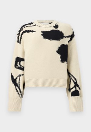 Beiger Strickpullover mit schwarzen abstrakten Blumenmustern auf Vorderseite, Ärmeln und Schultern, mit gerippten Bündchen und Saum.