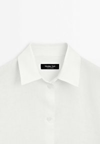 Wit linnen overhemd met een klassieke kraag en knoopsluiting, met een geweven textuur en een label met "Massimo Dutti".