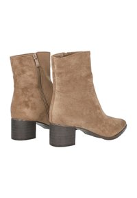 Botines de ante en color marrón claro con puntera redondeada, cremallera lateral y tacón de madera apilada. Textura suave y diseño simple y limpio.