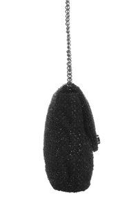 Černá kabelka vyrobená z texturovaného materiálu, s zaobleným tvarem a řetízkovým popruhem. Výrazné třpytivé akcenty po celé ploše.