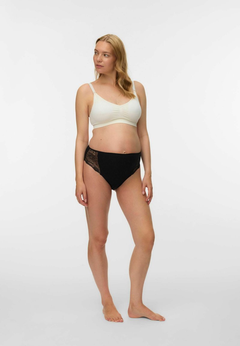 Crne gaćice s visokim strukom s čipkastim bočnim panelima u kombinaciji s grudnjakom od kremaste, mekane tkanine s naboranim detaljima.