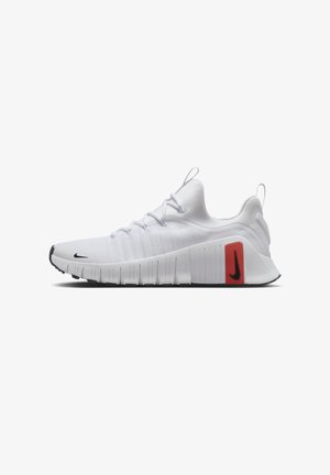 Baskets blanches de sport avec semelle flexible, swoosh Nike noir sur les orteils et le talon, et détail rectangulaire rouge sur le côté extérieur.