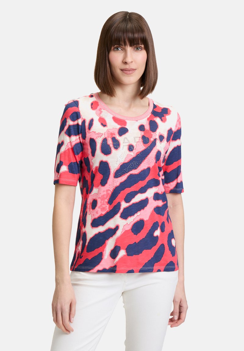 Short-sleeve, round-neck t-shirt in a pink, navy, and cream leopard print with a subtle shimmer detail and soft, textured fabric.