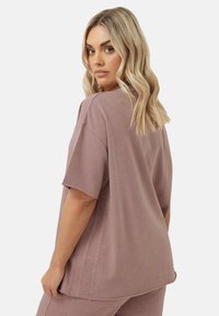Korte mouwen, oversized mauve t-shirt van zachte stof, met een ronde halslijn en een relaxte pasvorm met zijnaaddetails.