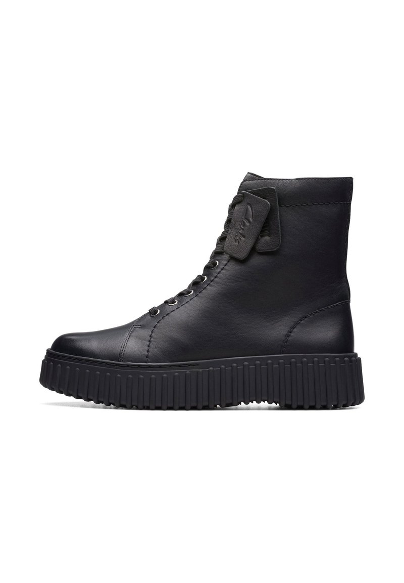 Bota alta de cuero negro con suela gruesa y acanalada, cordones y detalles cosidos, mostrada de perfil sobre un fondo blanco.