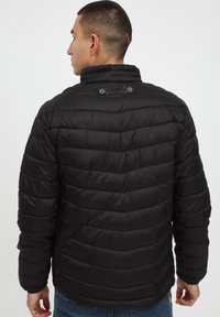 Black puffer jacket with horizontal quilted pattern, stand collar, and two visible buttons on the back. Smooth, shiny fabric texture.