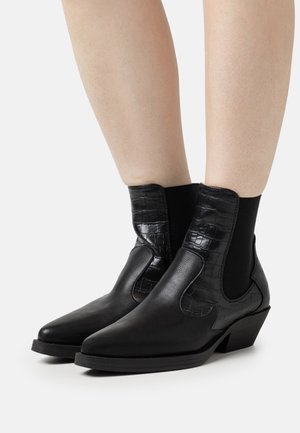 Schwarze Knöchelstiefel mit spitzer Zehe, aus einem Krokodilleder-Obermaterial mit Prägung und elastischen Seitenpaneelen für ein einfaches Anziehen.