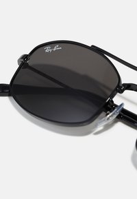 Mustad mustad Ray-Ban prillid ruudukujulise raamiga, tumedad läätsed ja läbipaistvad ninapadjad; stiilsed metallkäed koos delikaatse logo detailiga.