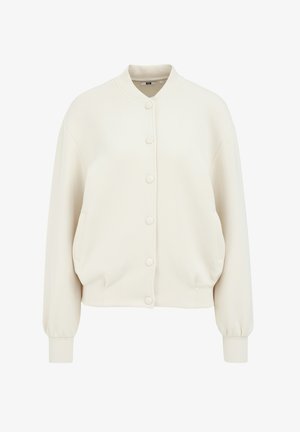 Chaqueta bomber color crema hecha de una tela suave. Presenta un cuello redondo, cierre de botones a presión, bolsillos laterales y puños acanalados.