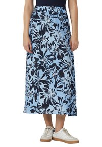 Maxi-rok in lichtblauw met een donkerblauw bloemenpatroon, elastische tailleband, lichte stof, enkel-lang ontwerp, gecombineerd met witte sneakers.