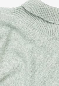 Helles grünes Strickpullover mit einem gerippten Kragen und einer weichen Textur in leicht lockerer Passform, die eine Mischung aus subtilen Fasern zeigt.