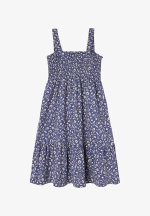 Blå ærmeløs kjole med hvidt blomstermønster, smocket liv og samlet nederdel med lagdelt kant.