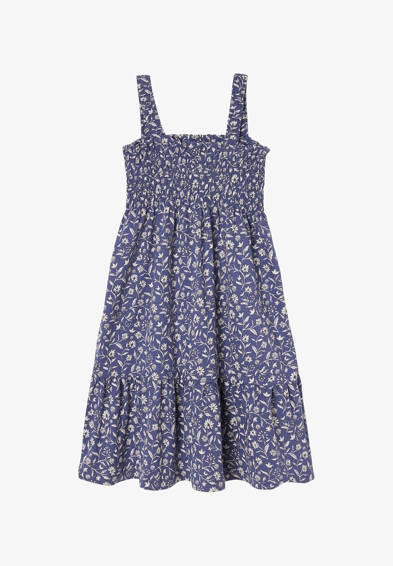 Robe bleue sans manches avec motif floral blanc, corsage smocké et jupe froncée avec ourlet échelonné.