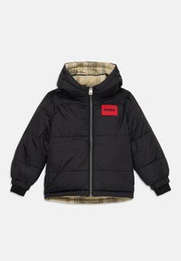 Sort puffjakke med hætte, fuld frontlynlås, elastiske manchetter, beige ternet foring og rød "HUGO" patch på brystet.