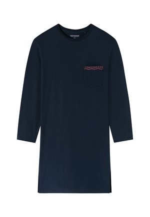 Marineblå långärmad skjorta i bomull, med en bröstficka som har en mönstrad accent i röd. Sidofickor vid fållen ger en design detalj.