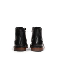 Botas de tobillo de cuero negro con un acabado suave, cierre de cremallera y suela de goma marrón en contraste. Presenta detalles de costura a lo largo de los bordes.