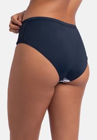 Augsta jostasvieta bikini apakšda jūras zilā krāsā, ar gludu tekstūru un smalku ziedu akcentu iekšējā oderē. Vienkāršs dizains bez rotājumiem.