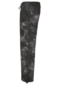 Čierne nohavice s tie-dye vzorom, vyrobené z mäkkej tkaniny, s elastickým pásom, šnúrkou na stiahnutie a bočnými vreckami. Úzke, zoštíhlené strihanie so zúžením pri členkoch.