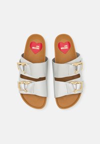 Sandali in faux pelle argentata con due ampie fascette, fibbie a forma di cuore dorate e una soletta color cammello con il logo a forma di cuore rosso.
