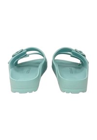 Un paio di sandali in gomma turchese senza chiusura, con suola testurizzata e dettaglio con fibbia floreale regolabile.