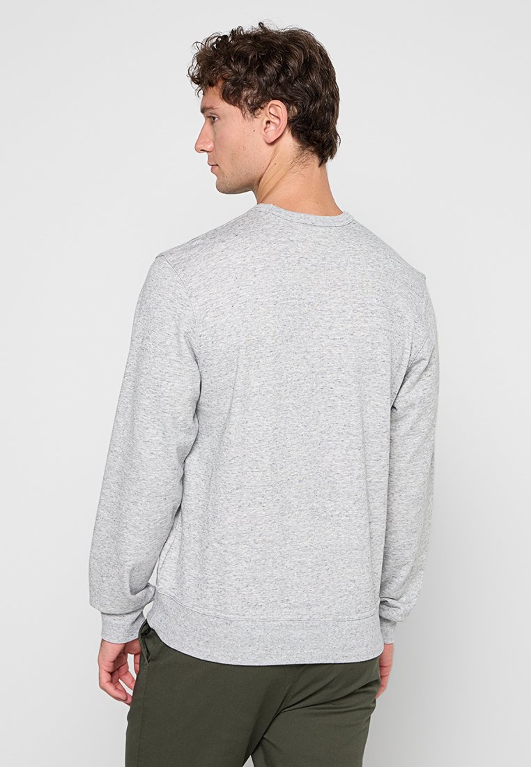 Felpa grigia con scollo rotondo classico, maniche lunghe, polsini a costine e un design dal fit rilassato.Texture morbida con una finitura melange.