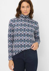 Maglione a collo alto con maniche lunghe in tessuto a fantasia caratterizzato da motivi a goccia in blu, verde e bianco, silhouette aderente, texture morbida e orlo curvo.
