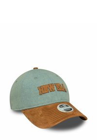 Baseballmütze aus hellblauem Stoff mit einem Schild aus braunem Wildleder; auf der Vorderseite befindet sich das gestickte "NEW ERA"-Logo sowie ein runder Markenaufkleber.