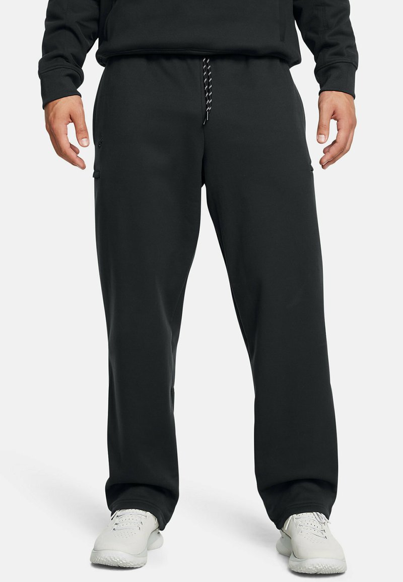 Črne trenirke z vrvico v pasu, elastičnimi zapenjali in stranskimi žepi, izdelane iz mehkega blaga za udobje.