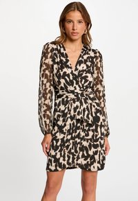 Geprinte jurk met een diepe V-hals, lange doorschijnende mouwen en een wikkelontwerp. Kleuren zijn onder meer beige, zwart en bruin met abstracte patronen.
