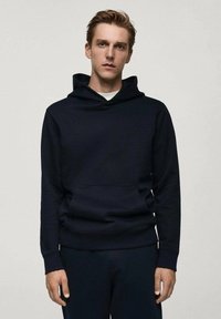 Námornícky modrá mikina s kapucňou vyrobená z mäkkej tkaniny, s klokankovým vreckom, širokým lemom a kapucňou so šnúrkou. Jednoduchý dizajn bez grafiky.