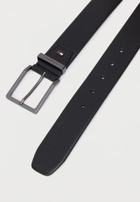 Sort læderbælte med et rektangulært metalspænde med en poleret finish. Inkluderer flere huller til justering og en logo-detalje.