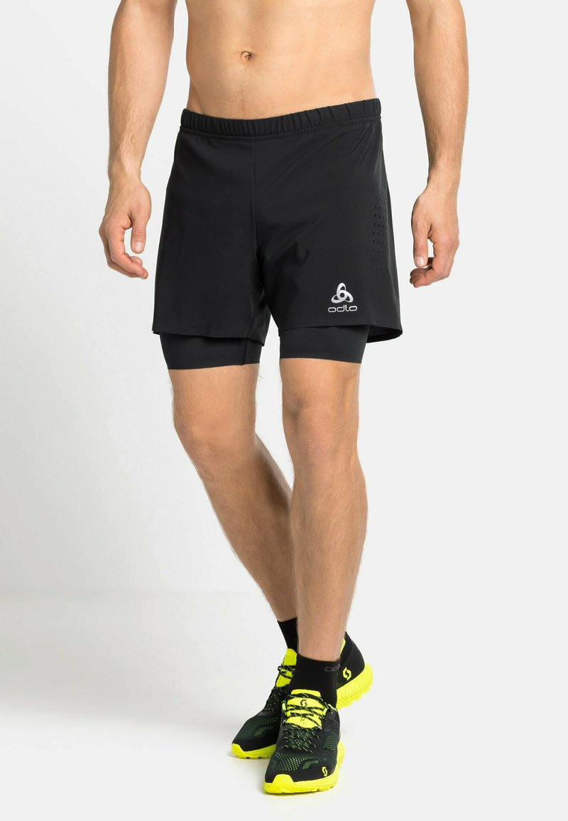 Zwarte sportshorts van lichtgewicht stof, met een elastische tailleband en perforaties aan de zijkant. Logo bevind zich op de zoom.