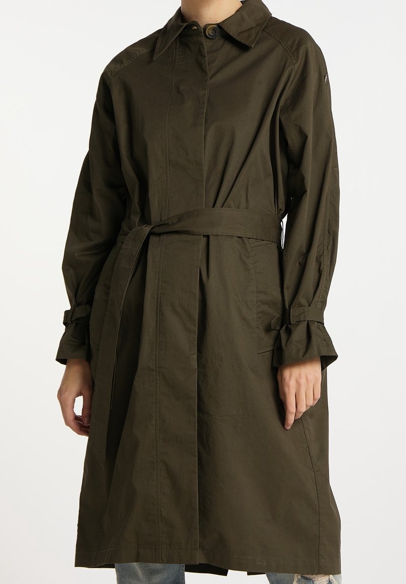 Płaszcz trencz w oliwkowym odcieniu, wykonany z mieszanki bawełny, z paskiem w talii, kołnierzem zapinanym na guziki oraz marszczonymi mankietami z detalami krawieckimi.