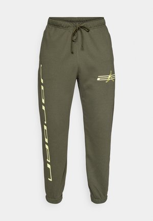 Pantalones deportivos verde oliva con cintura elástica y cordón, que presentan un logo amarillo y el texto vertical "JORDAN" en la pierna izquierda.
