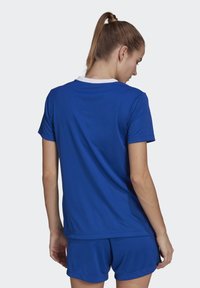 Blue athletic shirt with short sleeves, white collar, and a smooth, breathable fabric. Worn with matching blue shorts.