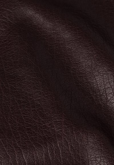 Texture in pelle marrone con una finitura a ciottoli, che mostra pieghe e profondità. Il materiale è liscio con sottili variazioni di tonalità.