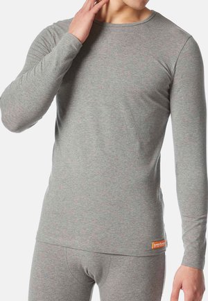 Grijze langemouwen shirt gemaakt van zachte, gestructureerde stof; heeft een eenvoudige ronde hals en een klein oranje merklabel aan de onderzoom.
