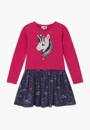 Pinkes Langarmkleid mit einem Pailletten-Einhornkopf auf der Brust und einem dunkelblauen Rock mit Stern- und Einhornmustern.