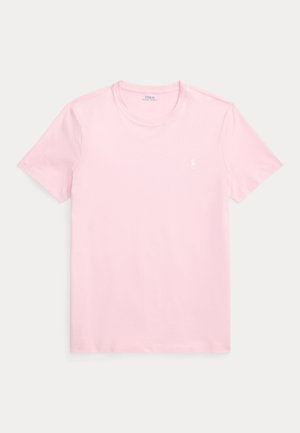 Világos rózsaszín pamut póló kerek nyakkal és rövid ujjakkal. Bal mellrészen kis fehér logóval. Puha tapintású. Klasszikus szabás.